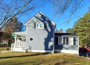 An after shot of a large 2-story home with new blue siding.